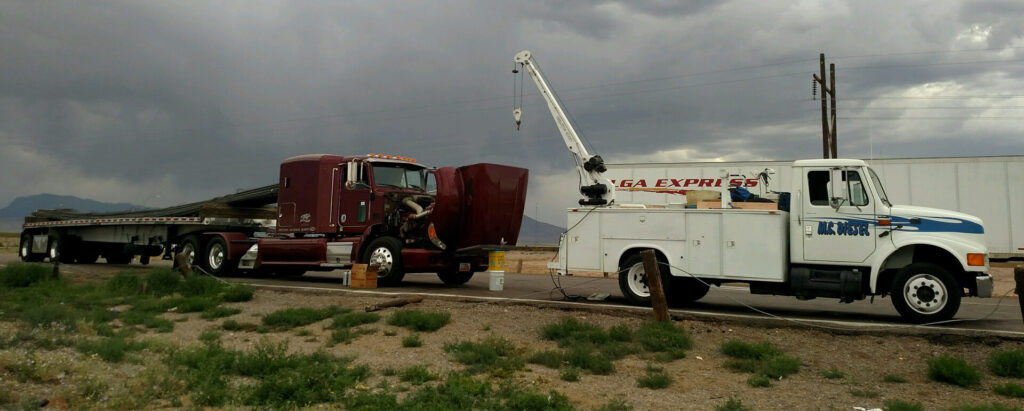 Mobile diesel service truck working on a semi truck on the roadside